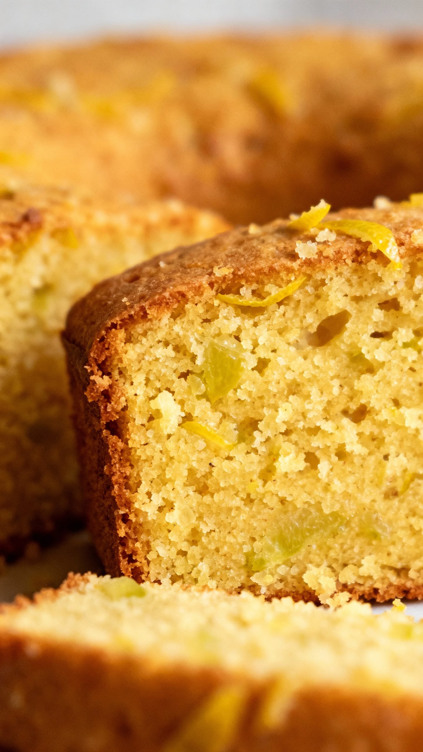 Slice of olive oil citrus polenta cake, lemon zest, coarse crumb low-sugar